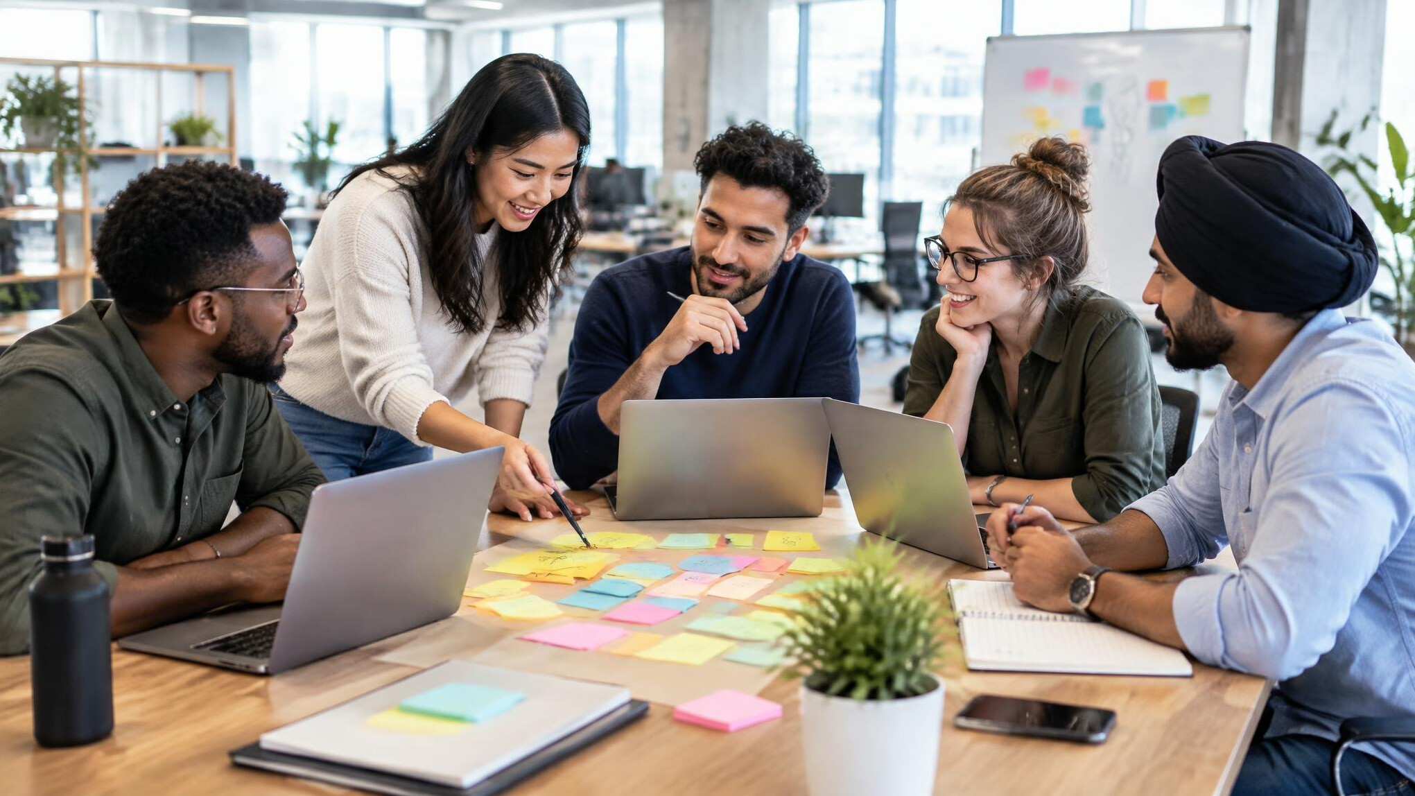 Team collaborating around laptops in an office